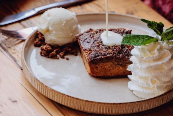 Een heerlijke sticky toffee taart wordt overgoten met vanille saus