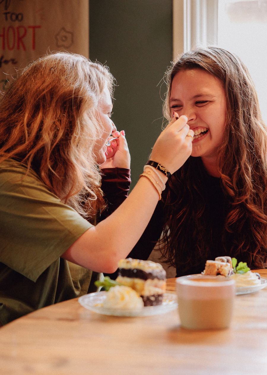 Twee vriendinnen voeren elkaar een hapje